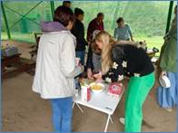 A group of people standing around a table

Description automatically generated